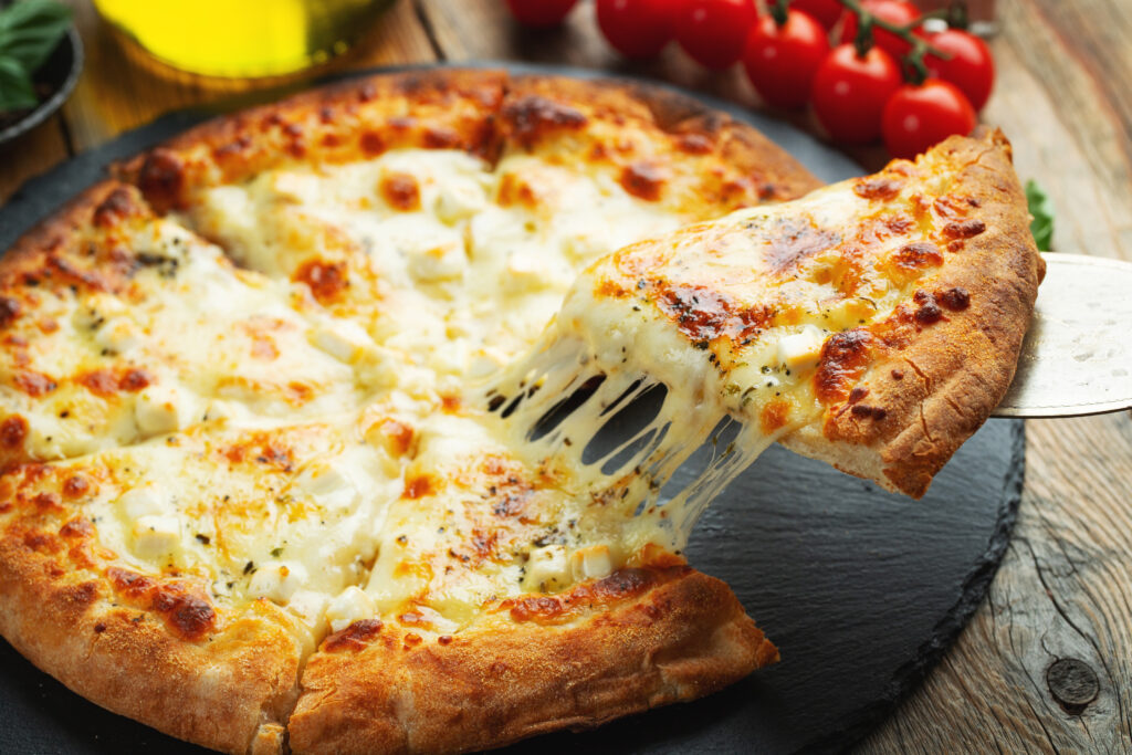Una rebanada de pizza italiana caliente con queso estirable.