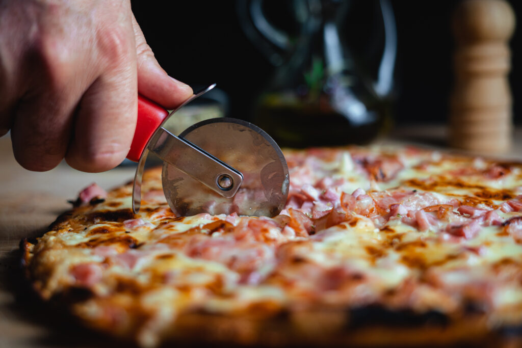 Una pizza casera cortada con un cortador de pizza.
